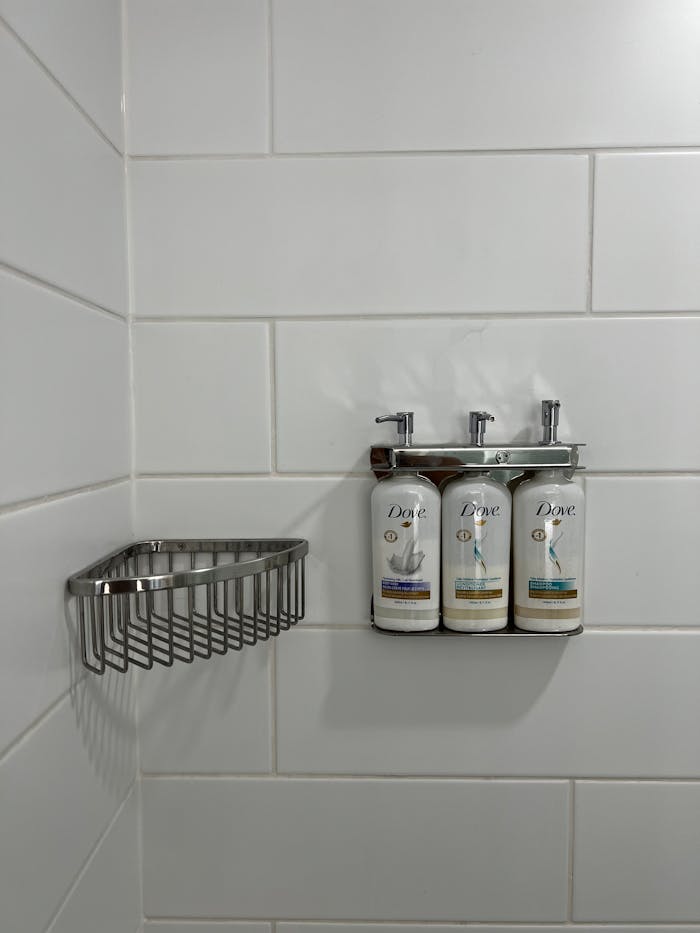 A shower with a shower head and soap dispenser